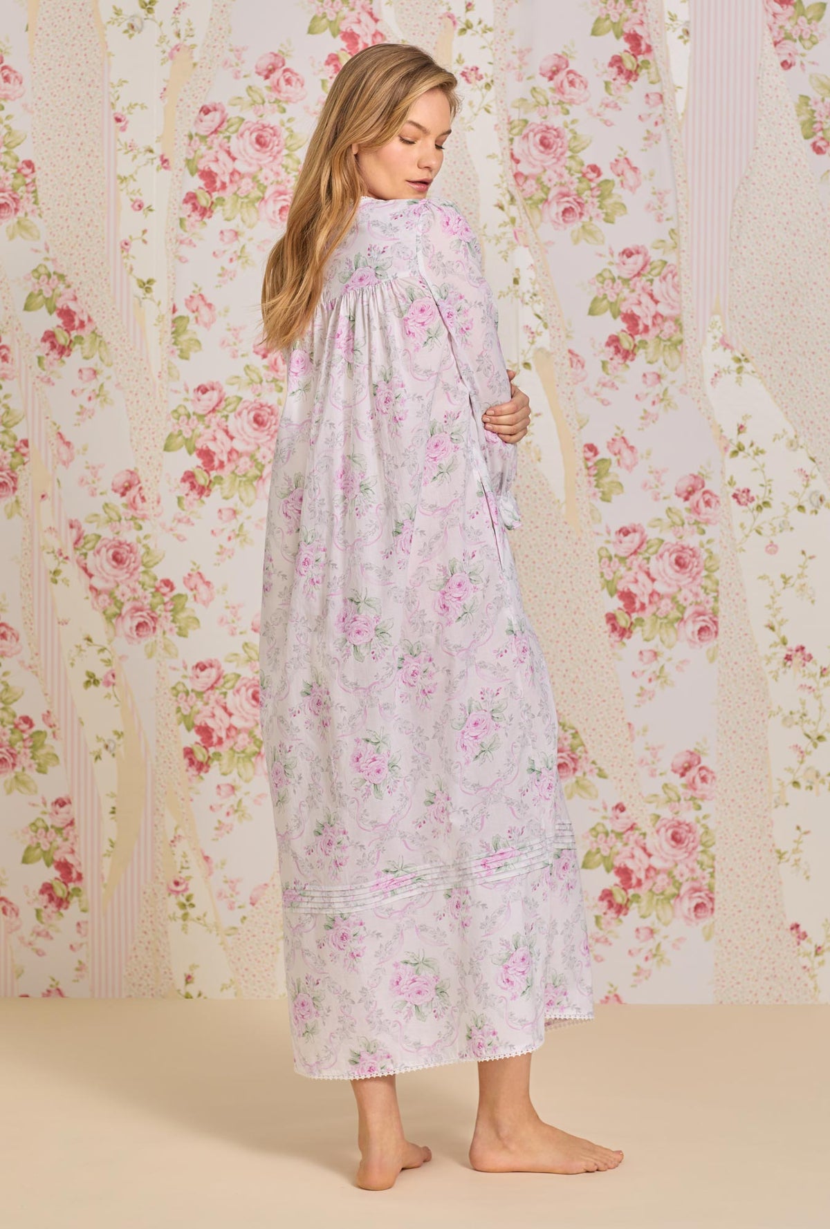 A lady wearing pink long sleeve cotton nightgown with victorian roses.