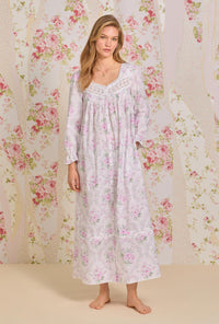 A lady wearing pink long sleeve button front cotton robe with victorian roses print.