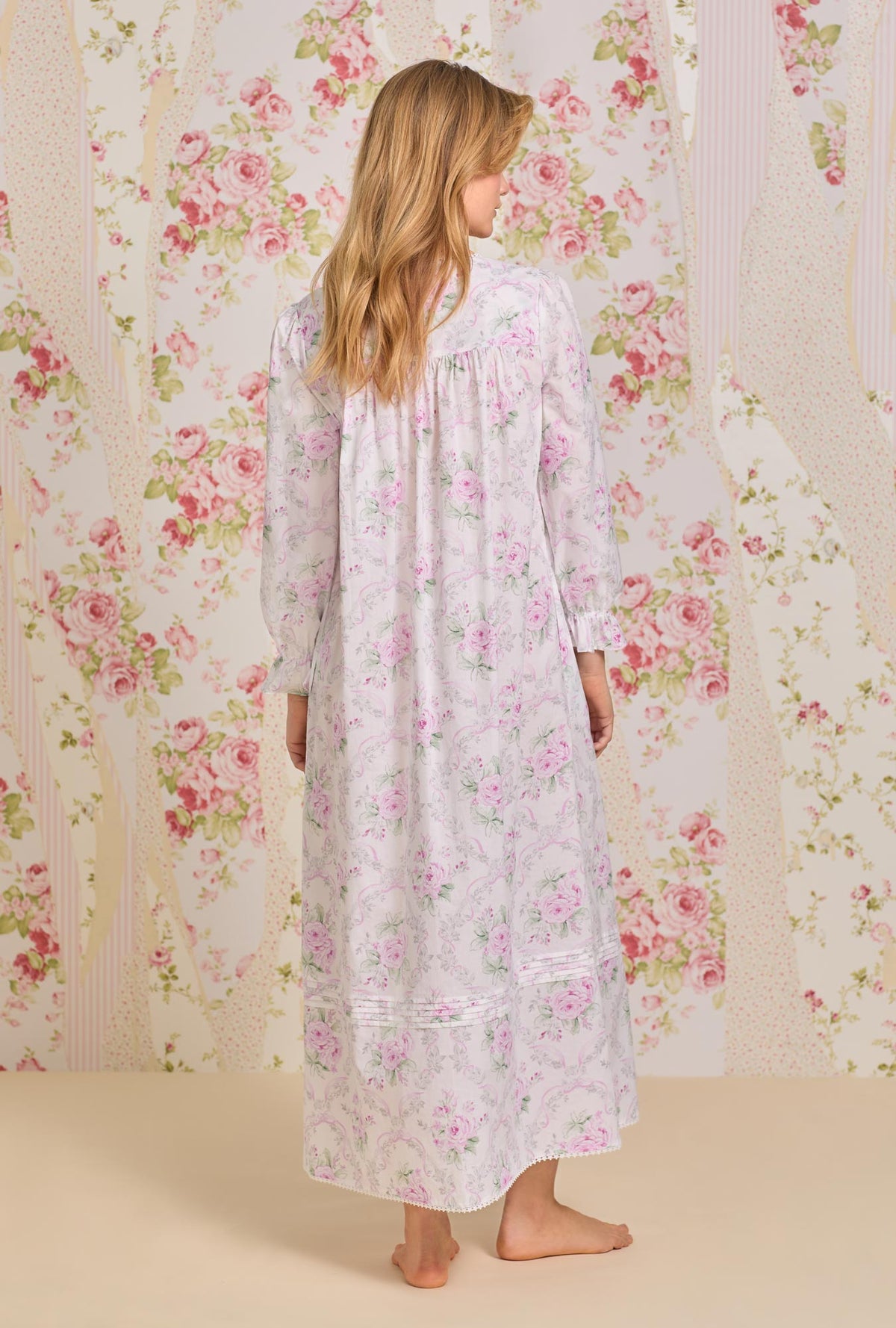 A lady wearing pink long sleeve button front cotton robe with victorian roses print.