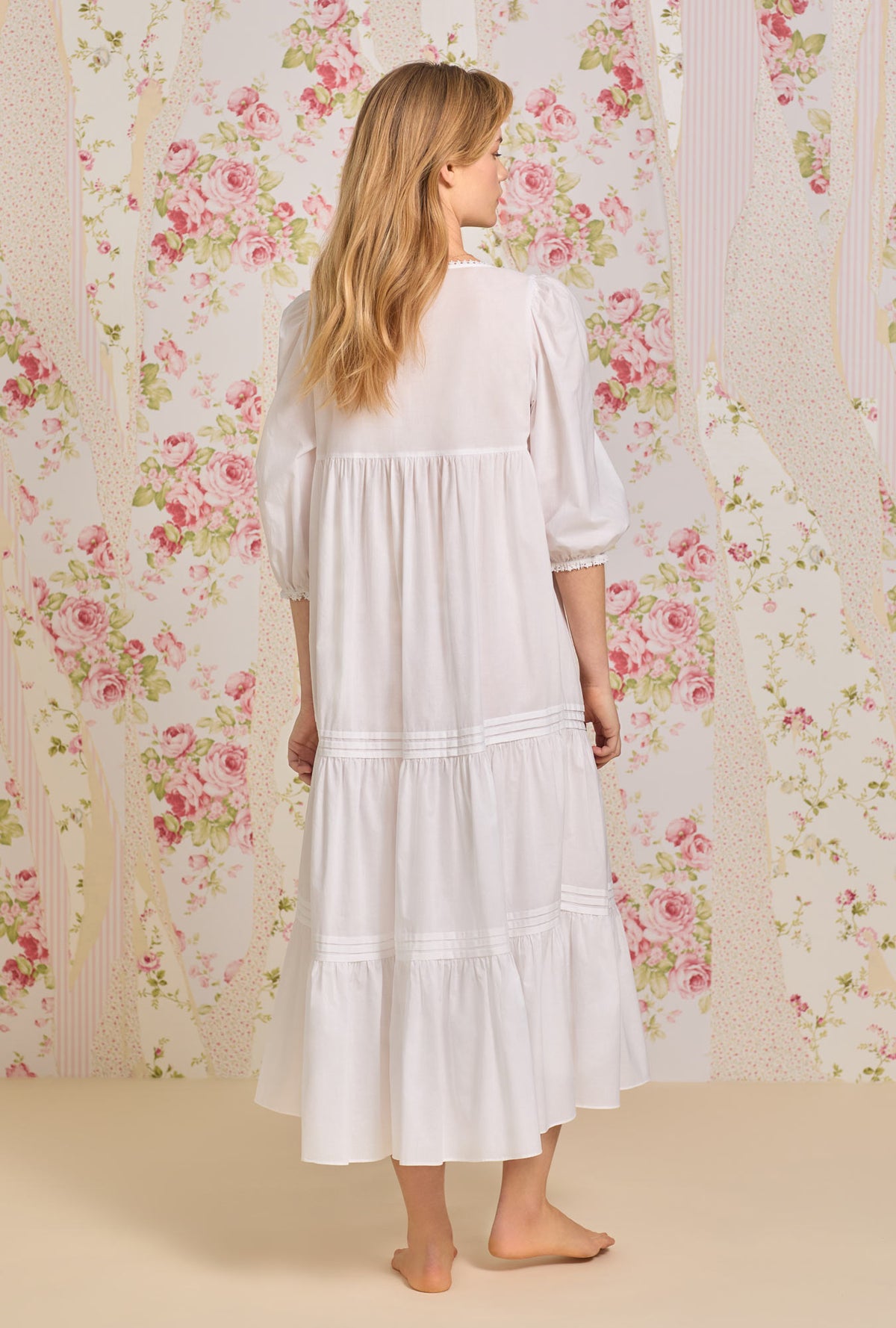 A lady wearing white 3/4 sleeve nightgown