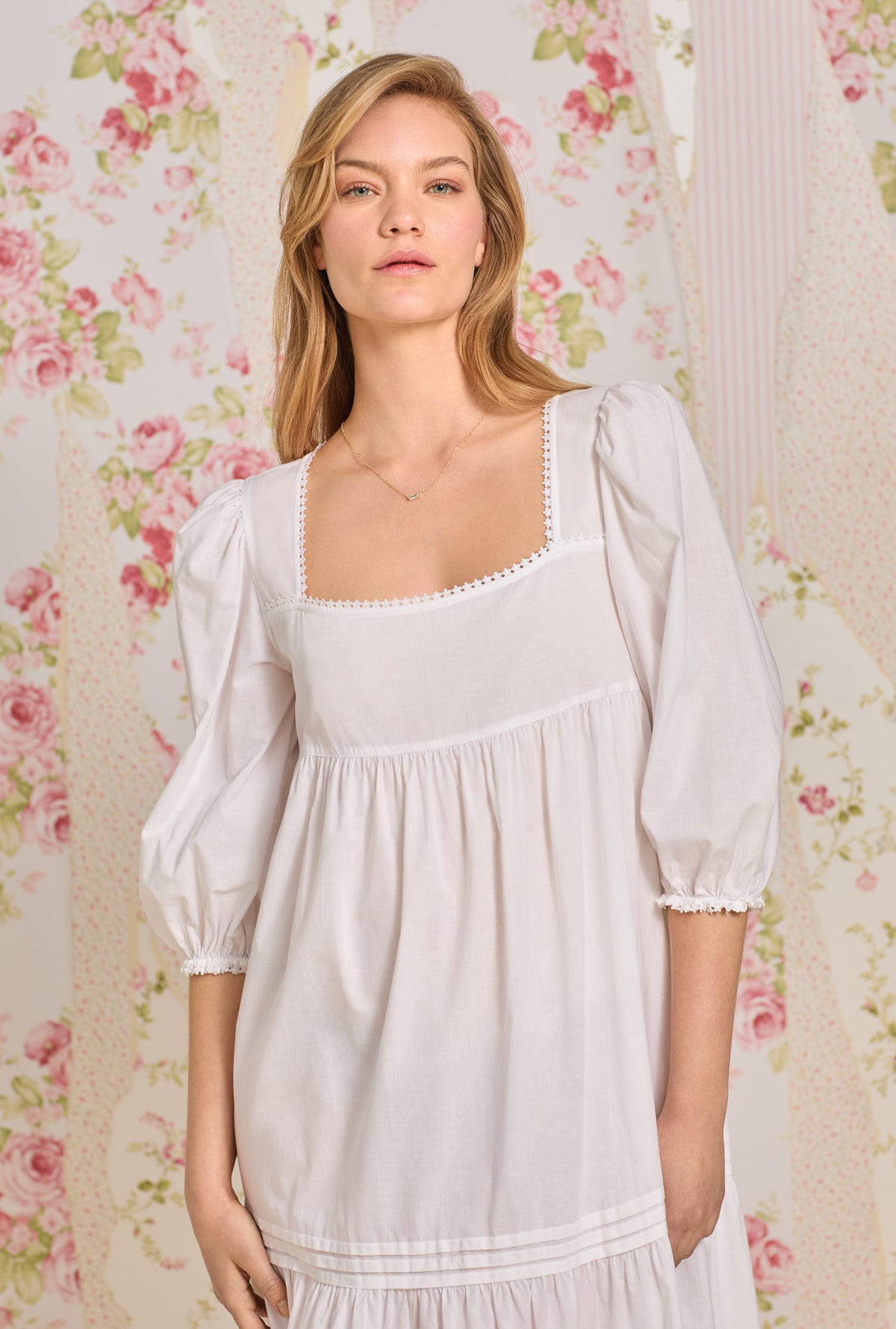 A lady wearing white 3/4 sleeve nightgown