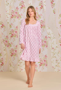 A lady wearing pink long sleeve short cotton knit nightgown with trellis rose print.